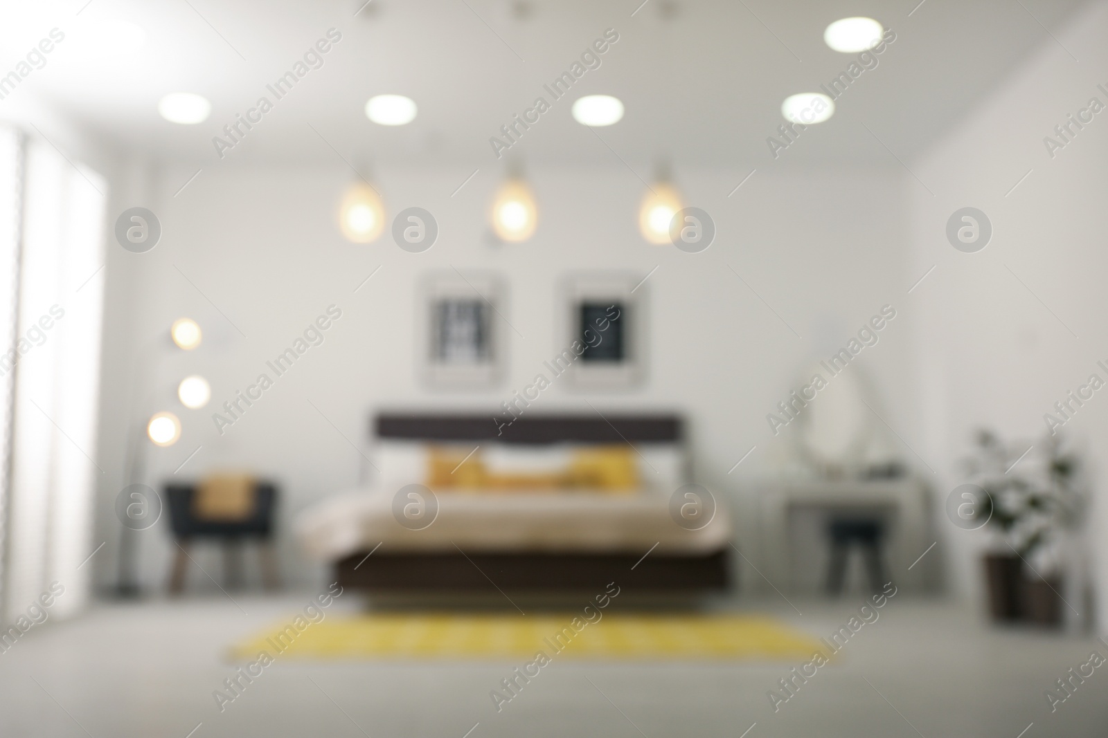 Photo of Blurred view of stylish room interior with comfortable bed