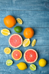 Many fresh citrus fruits on wooden table