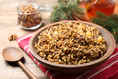 Photo of Traditional Christmas slavic dish kutia served on wooden table, closeup