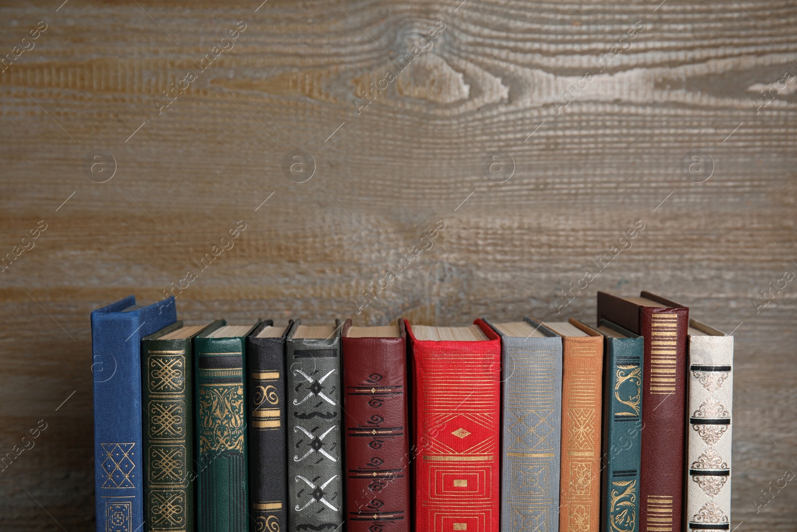 Photo of Stack of hardcover books on wooden background. Space for text