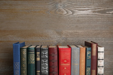 Photo of Stack of hardcover books on wooden background. Space for text