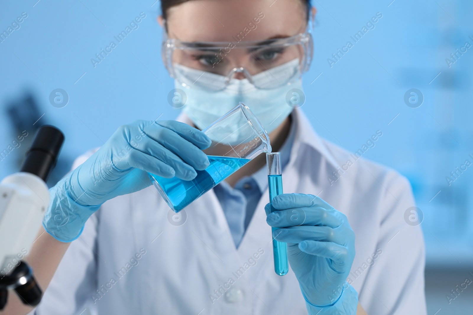 Photo of Scientist working with beaker and test tube in laboratory, closeup