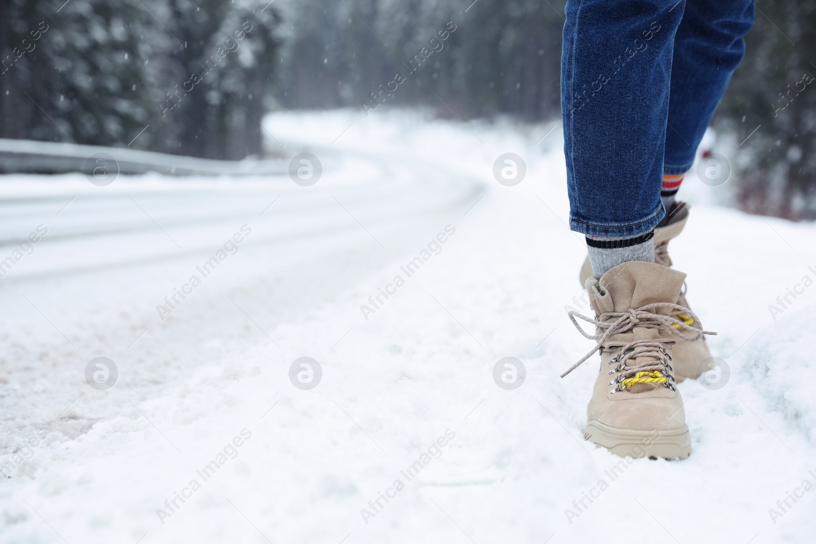 Photo of Woman walking outdoors on snowy winter day. Space for text