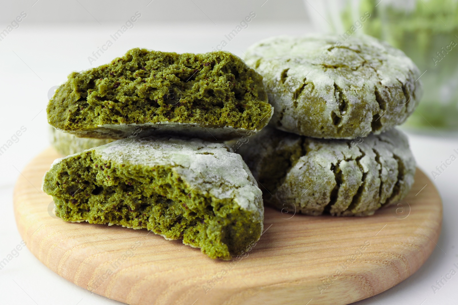 Photo of Board with stacked tasty matcha cookies on white table, closeup