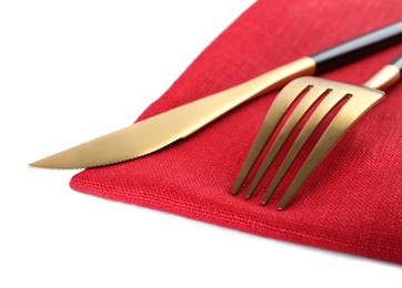 Photo of Red napkin with golden fork and knife on white background, closeup