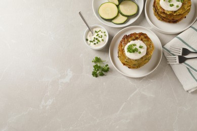 Photo of Delicious zucchini pancakes served on light grey table, flat lay. Space for text