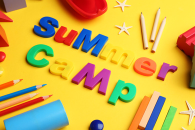 Photo of Composition with phrase SUMMER CAMP made of magnet letters on yellow background