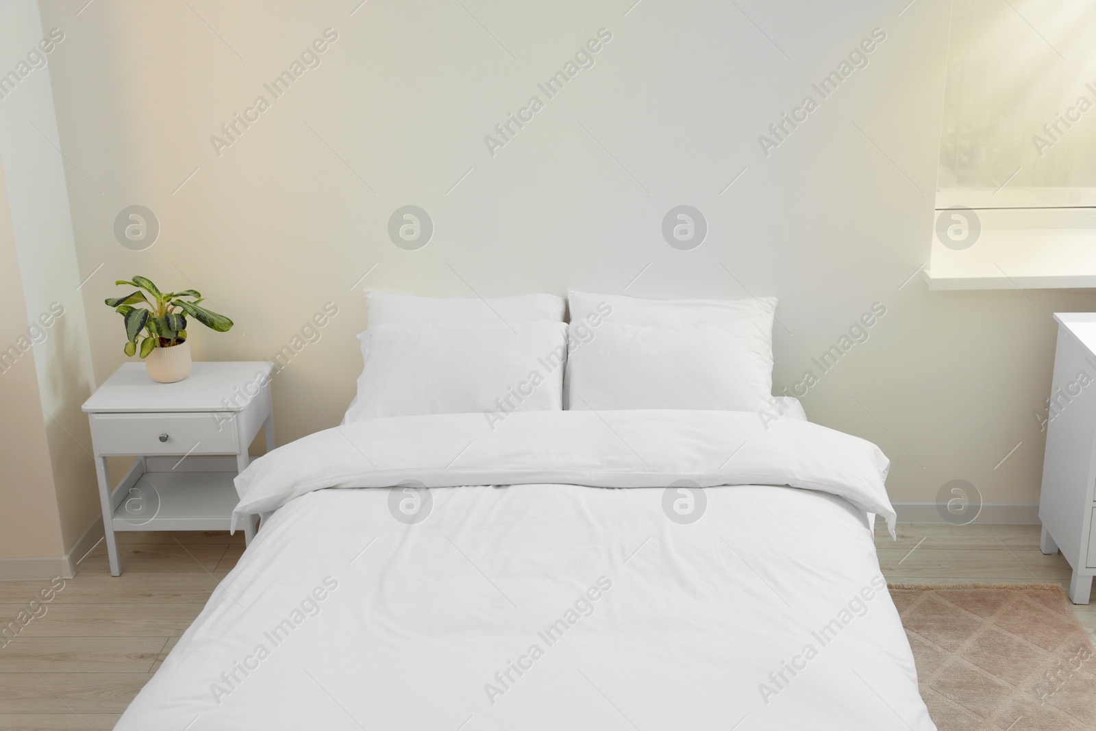 Photo of White soft pillows on cozy bed in room