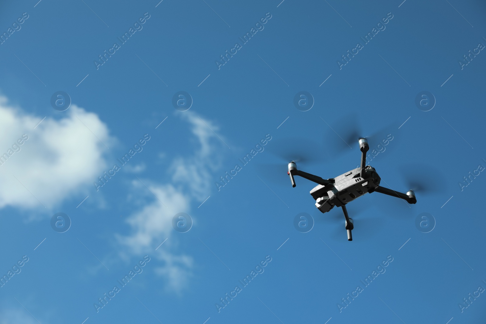 Photo of Modern drone with camera flying in sky on sunny day