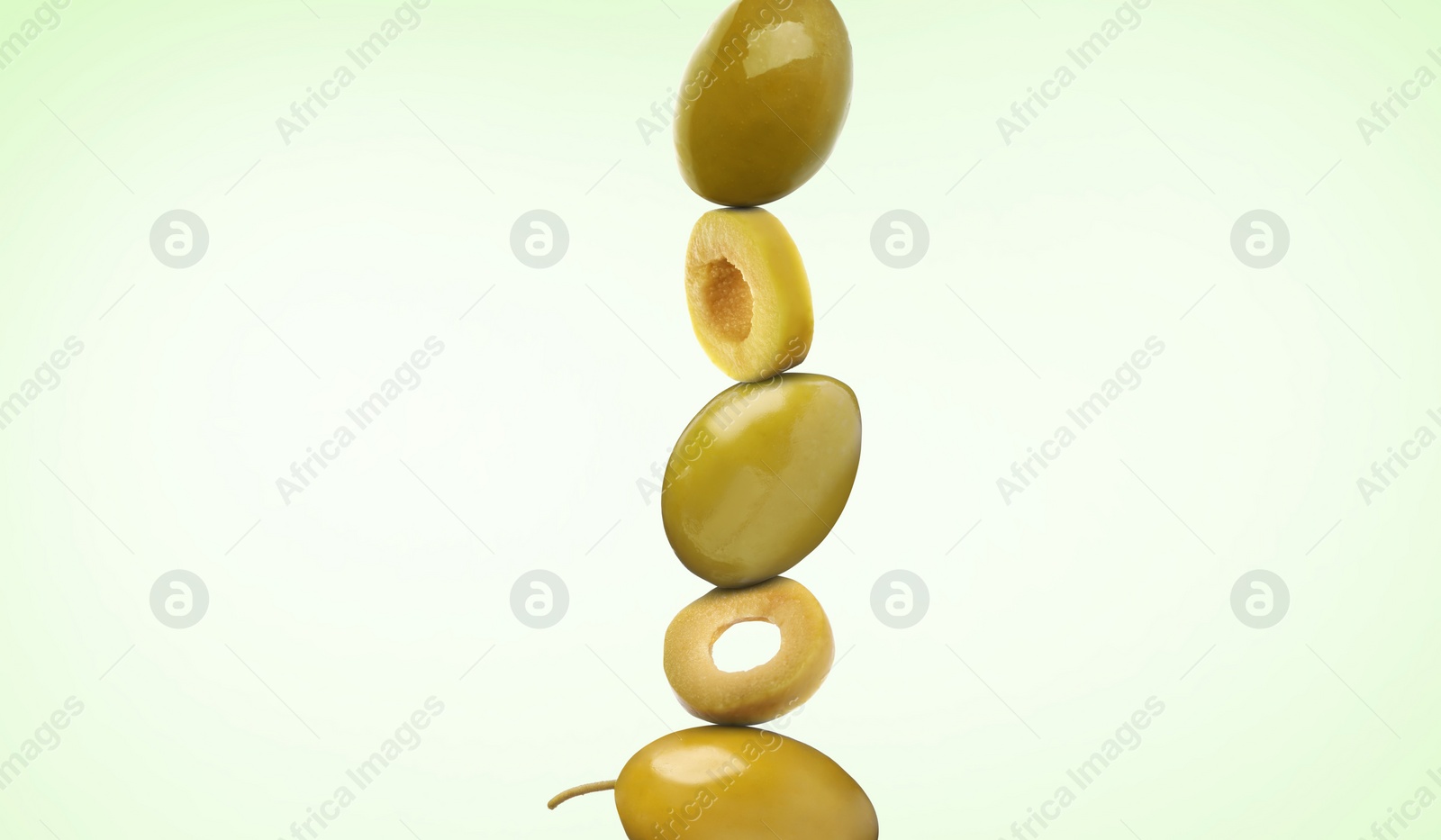 Image of Cut and whole olives on light green gradient background