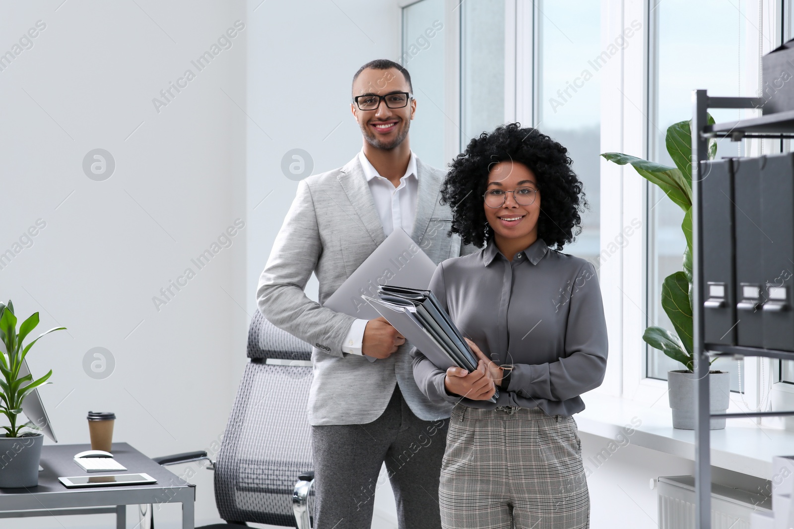 Photo of Young colleagues with folders in modern office