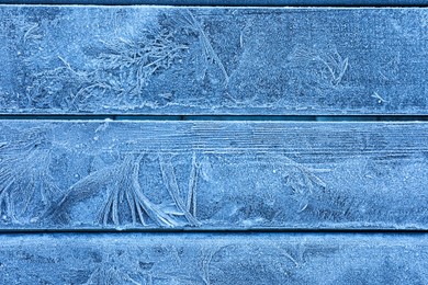 Photo of Beautiful hoarfrost on wooden background, top view