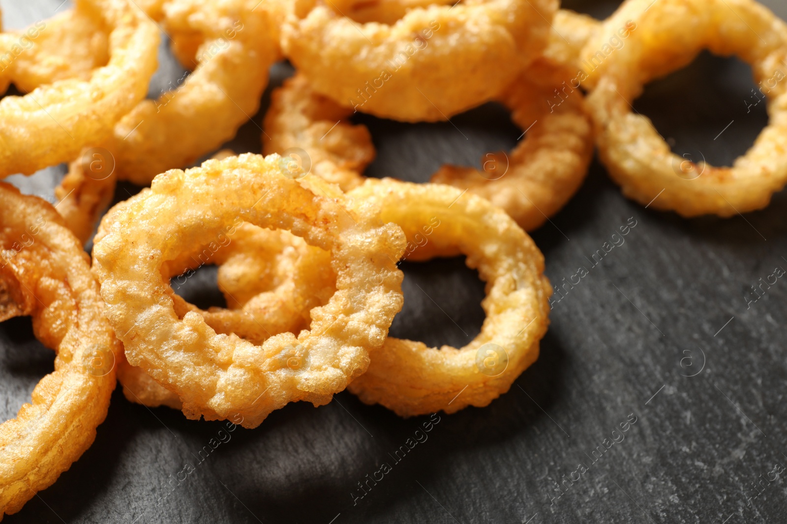 Photo of Homemade crunchy fried onion rings on table, closeup
