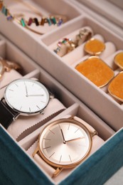 Photo of Elegant jewelry box with beautiful bijouterie and expensive wristwatches, closeup