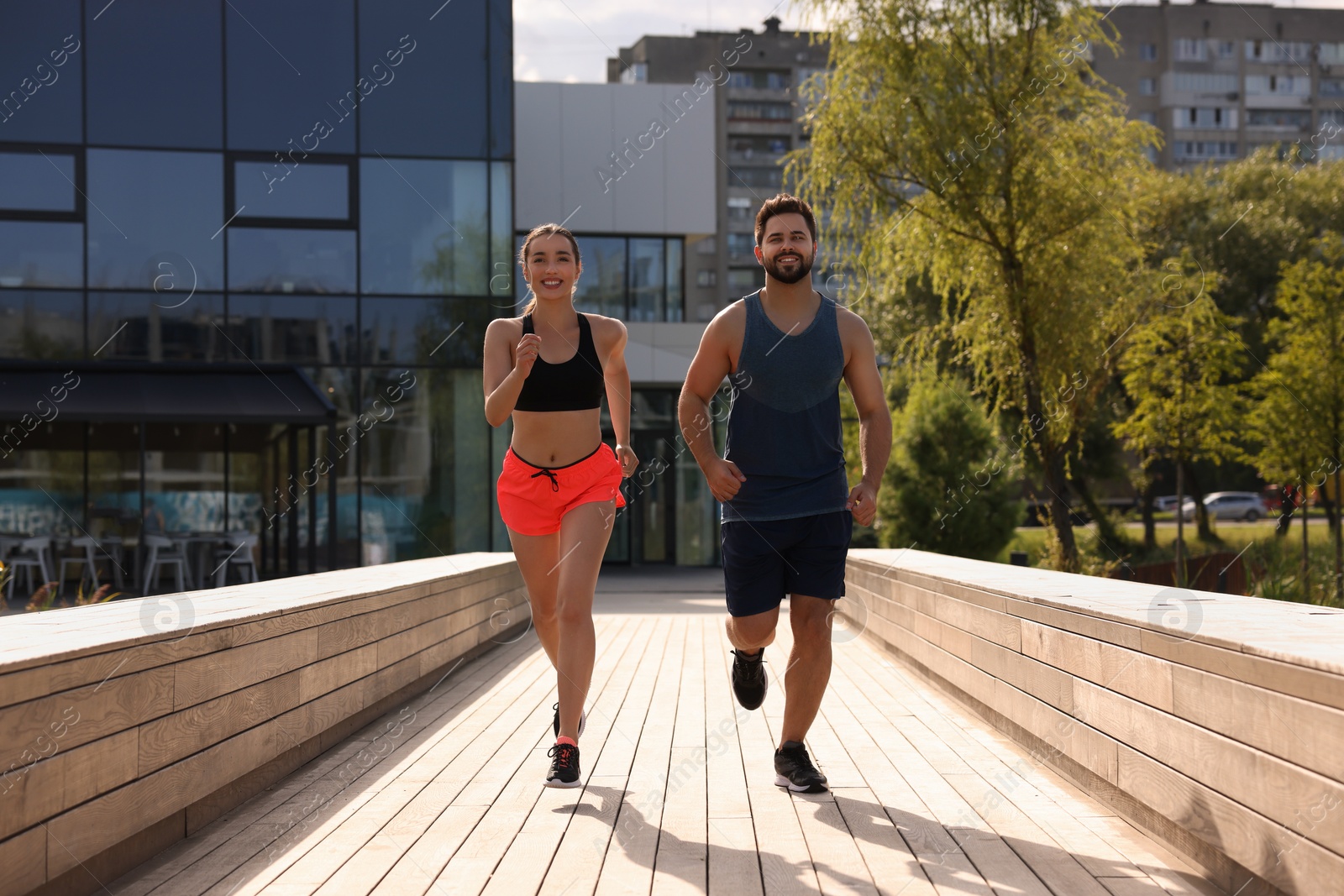 Photo of Healthy lifestyle. Happy couple running outdoors on sunny day