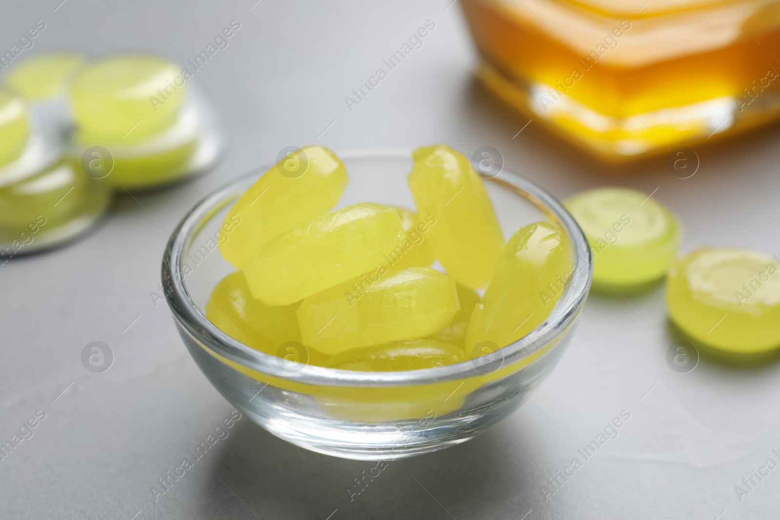 Photo of Many yellow cough drops on light grey table