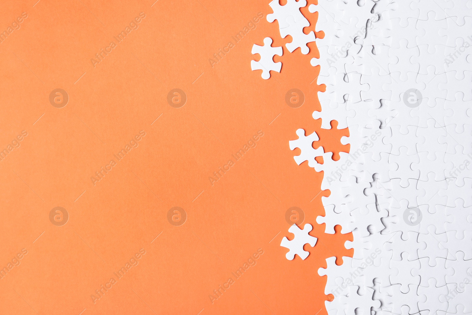 Photo of Blank white puzzle pieces on orange background, flat lay. Space for text