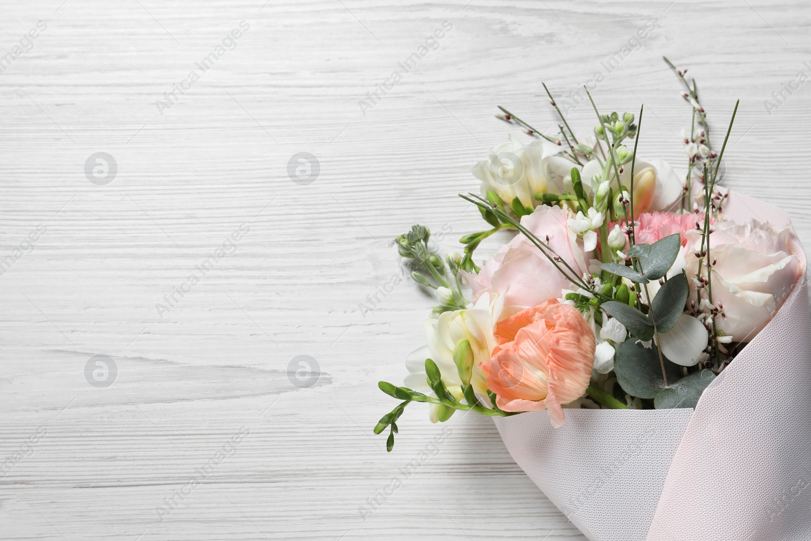 Photo of Bouquet of beautiful flowers on white wooden table, top view. Space for text