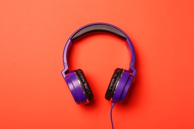 Stylish modern headphones on color background, top view