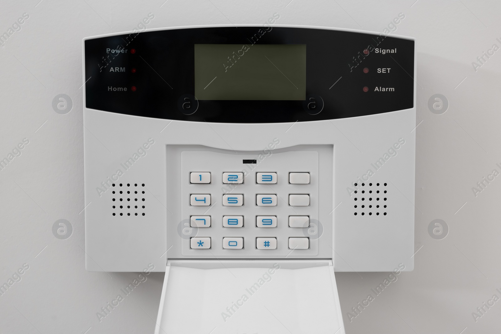 Photo of Home security alarm system on white wall indoors