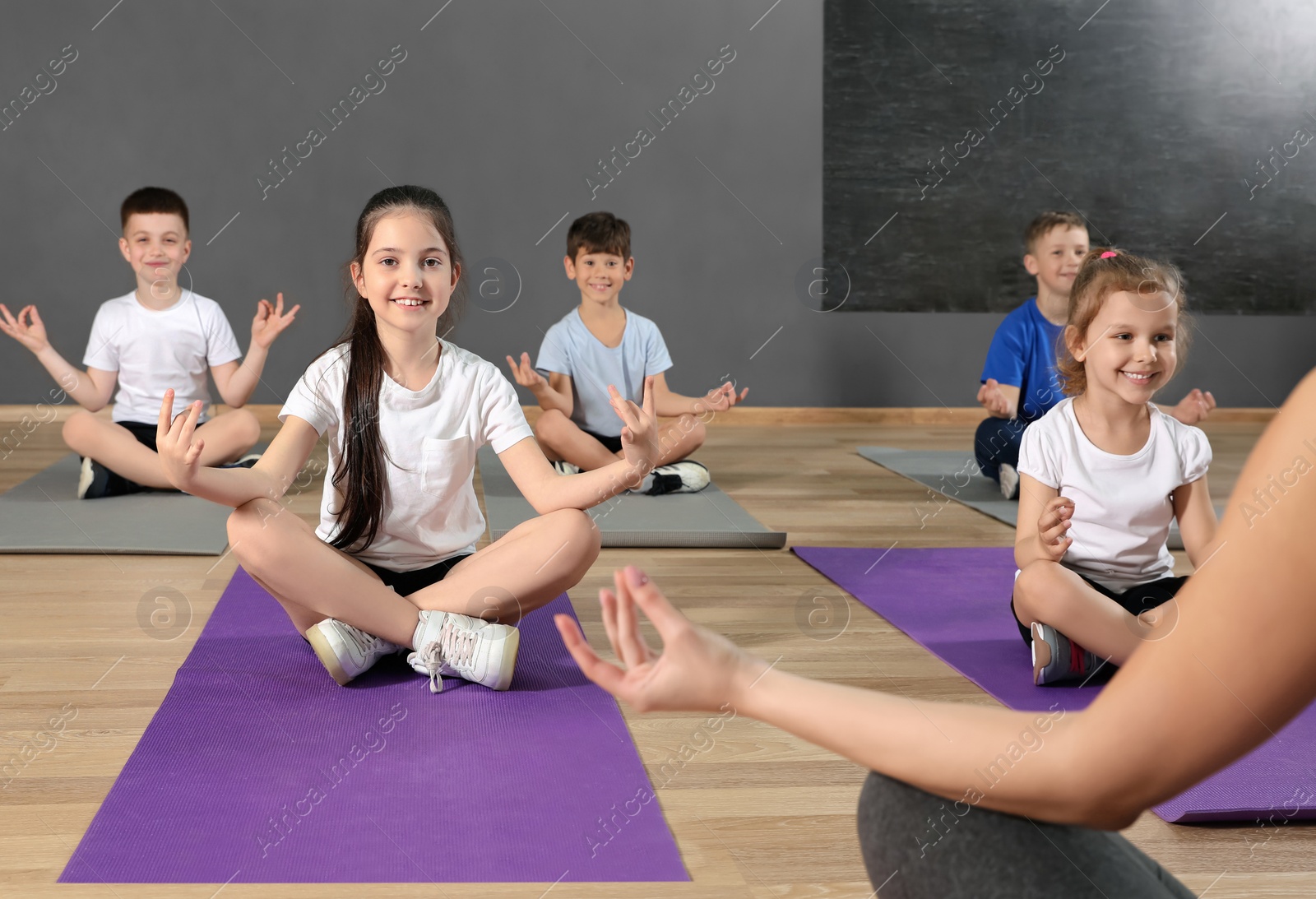 Photo of Cute little children and trainer doing physical exercise in school gym. Healthy lifestyle