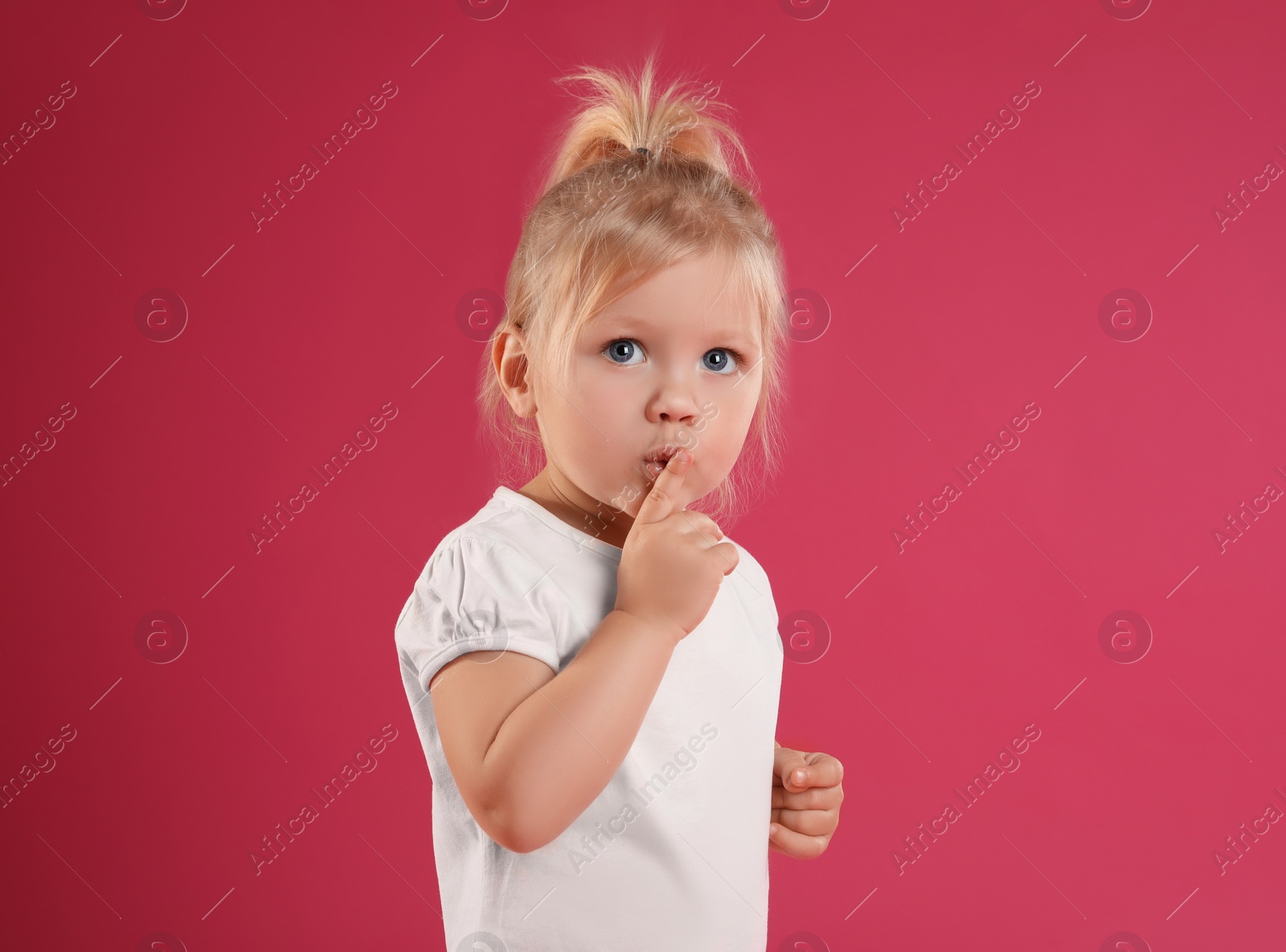 Photo of Portrait of emotional little girl on pink background