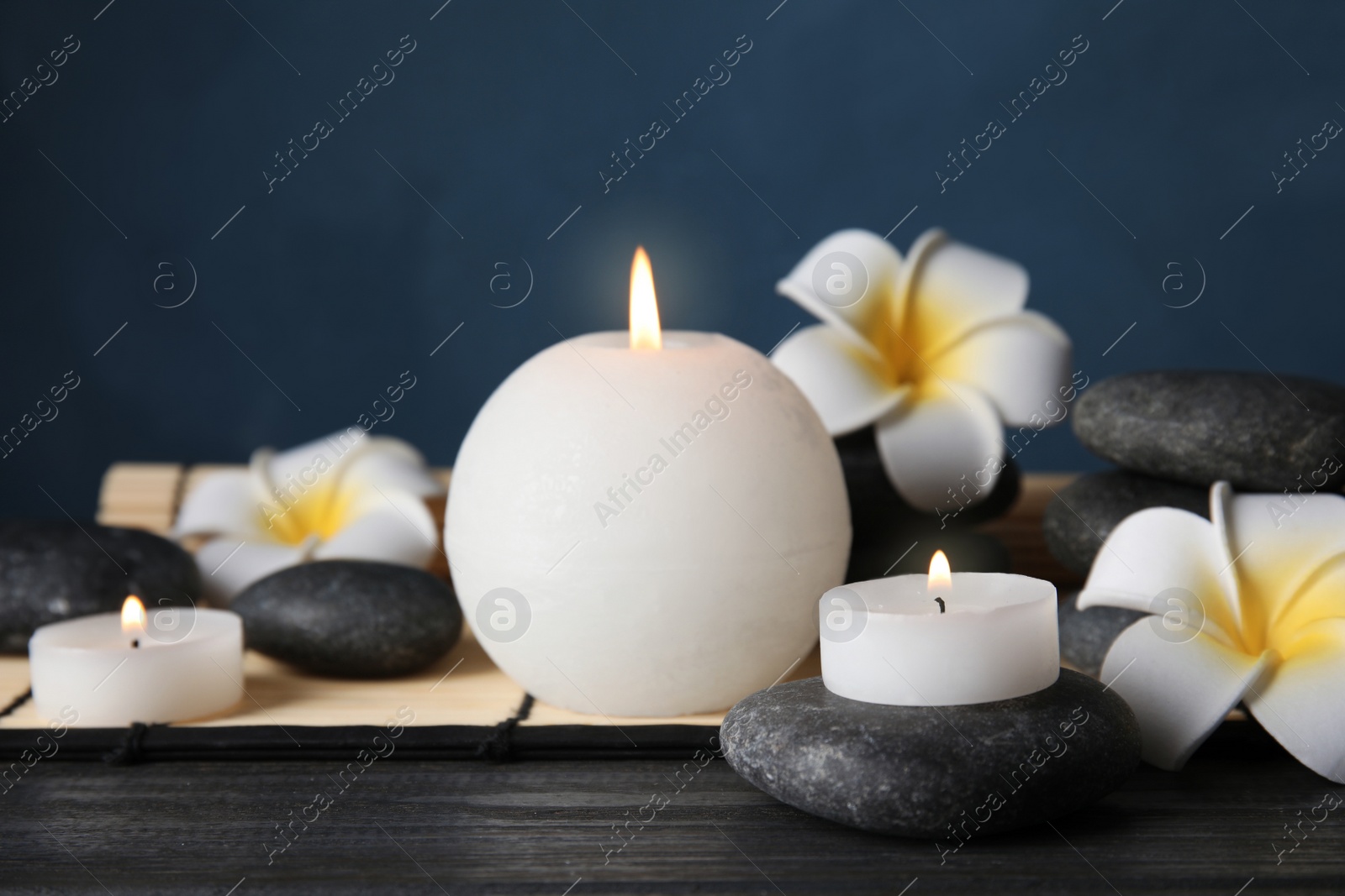 Photo of Spa stones, candles and flowers on table