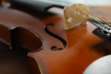 Photo of Beautiful violin on wooden table, closeup view