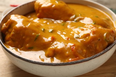 Photo of Tasty chicken curry on wooden board, closeup