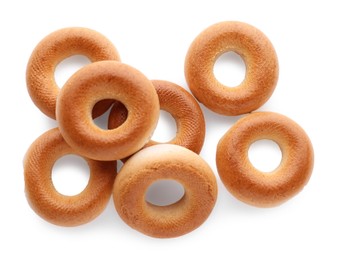 Photo of Many tasty dry bagels (sushki) isolated on white, top view