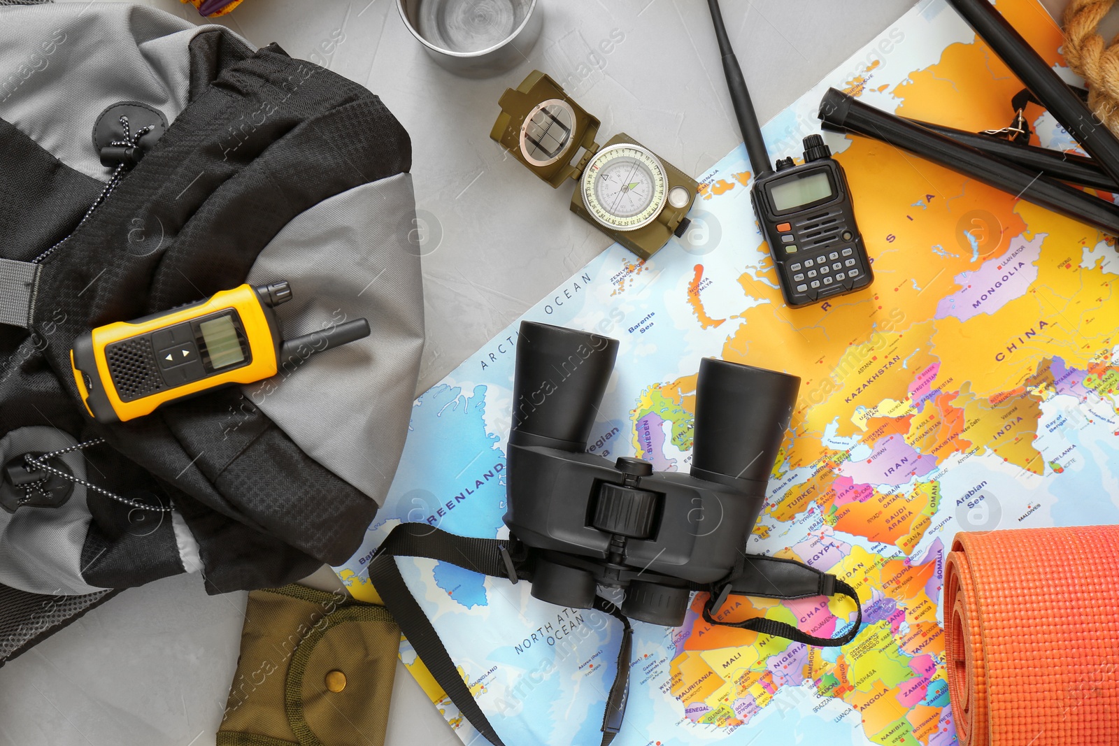 Photo of Flat lay composition with map and camping equipment on grey background