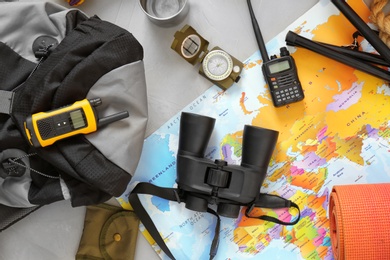 Photo of Flat lay composition with map and camping equipment on grey background