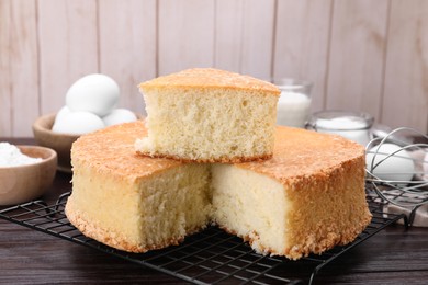 Photo of Tasty sponge cake on wooden table, closeup