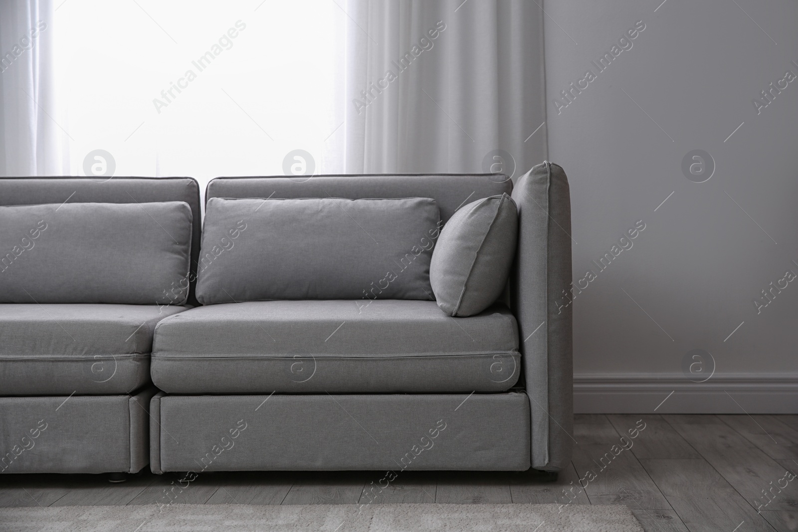 Photo of Simple living room interior with comfortable sofa near window