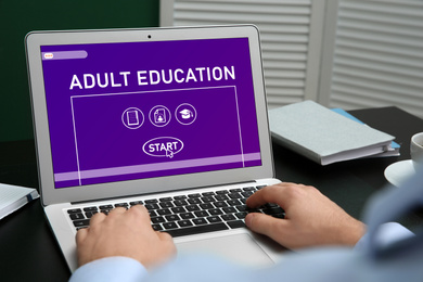 Man using laptop for online studying indoors, closeup. Adult education 