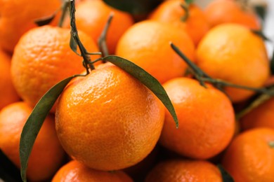 Photo of Fresh ripe tangerines and leaves as background, closeup