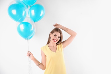 Young woman with air balloons on white background