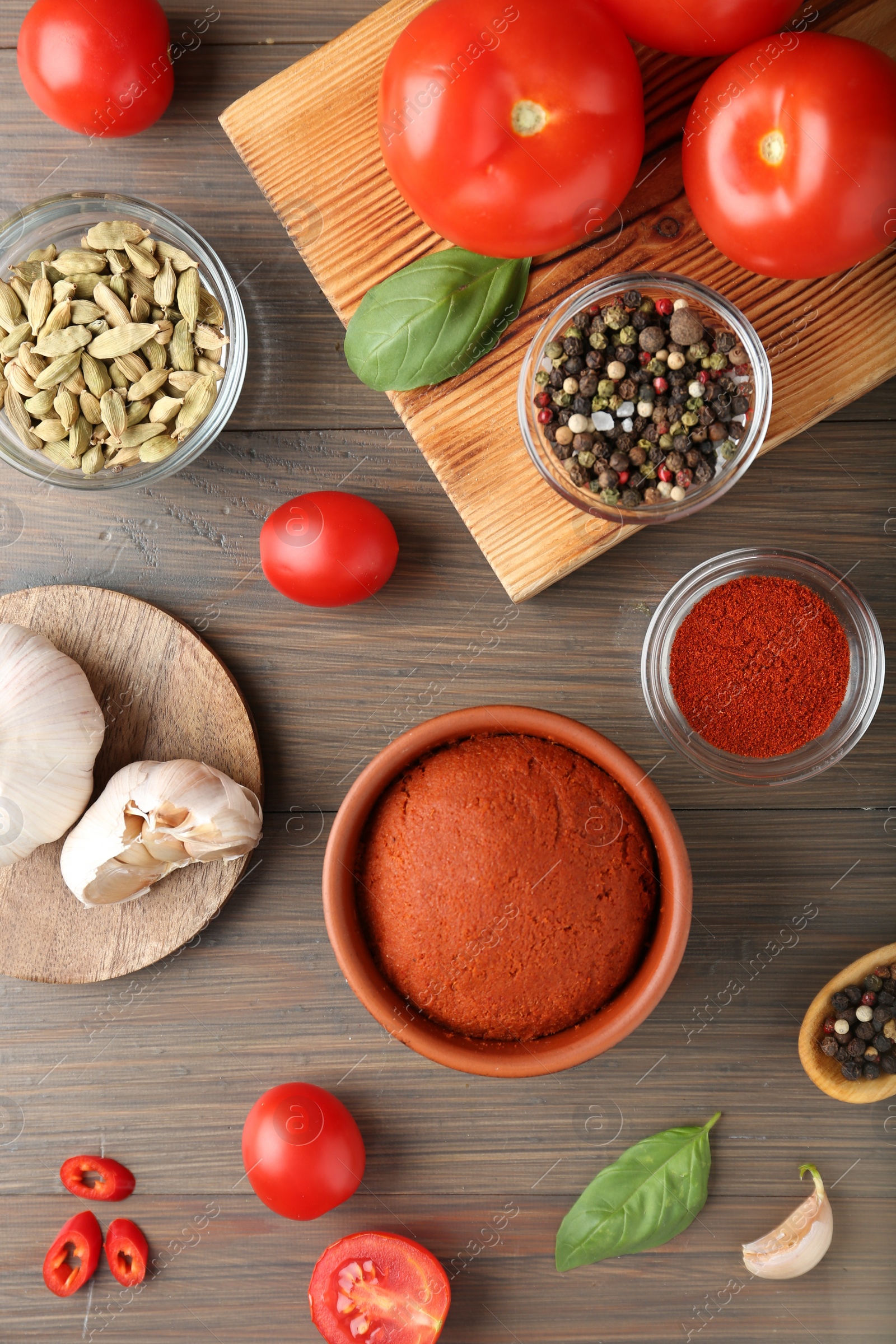 Photo of Red curry paste and ingredients on wooden table, flat lay