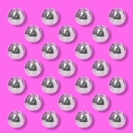 Many shiny disco balls on pink background, flat lay