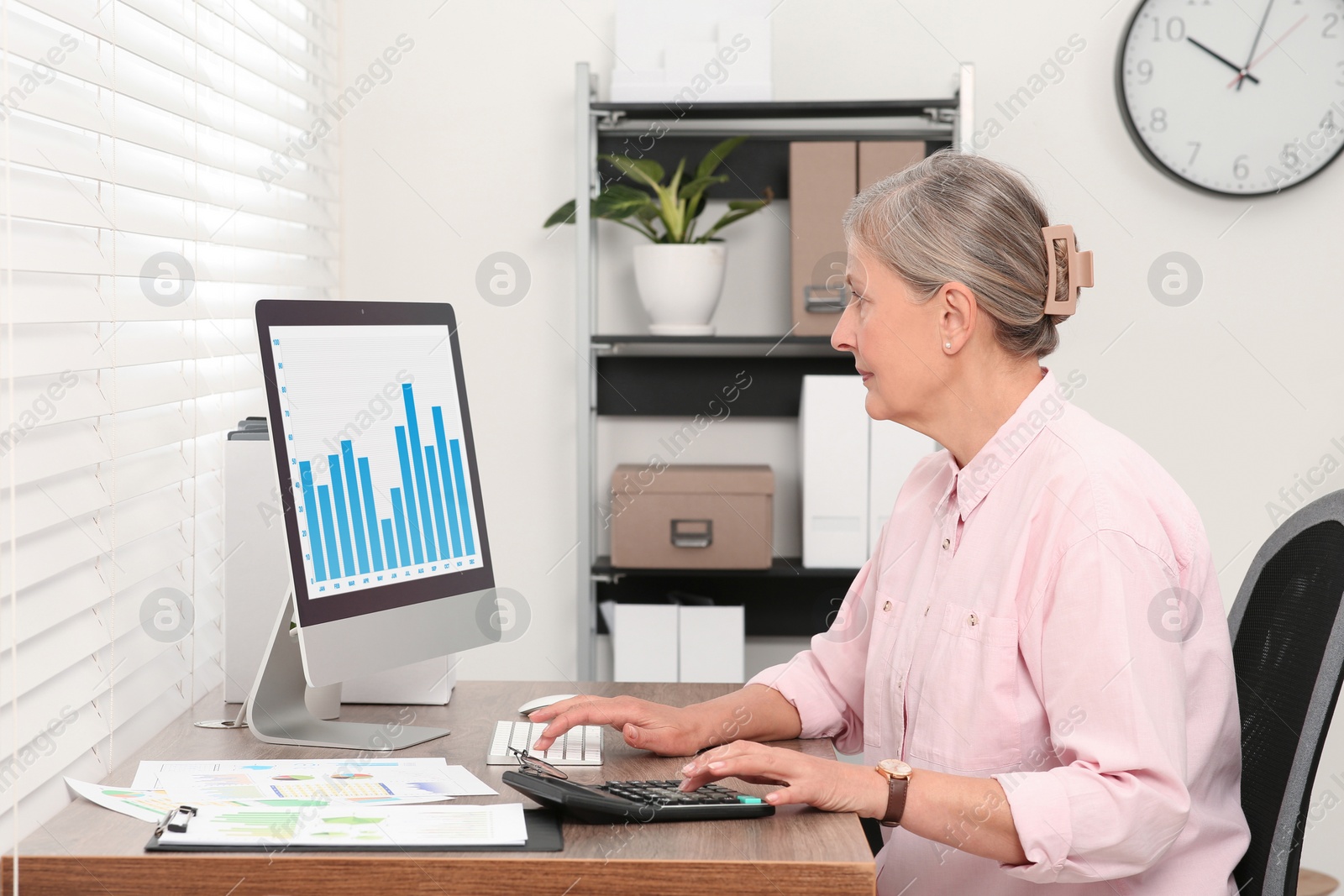 Photo of Senior accountant working at wooden desk in office