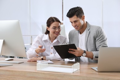 Businessman helping intern with work in office