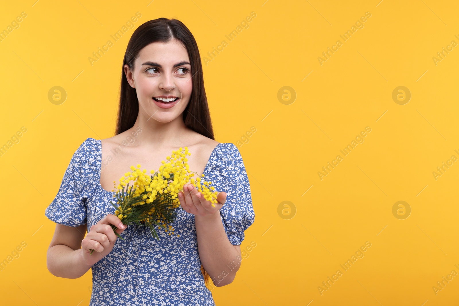 Photo of Happy young woman with beautiful bouquet on orange background. Space for text