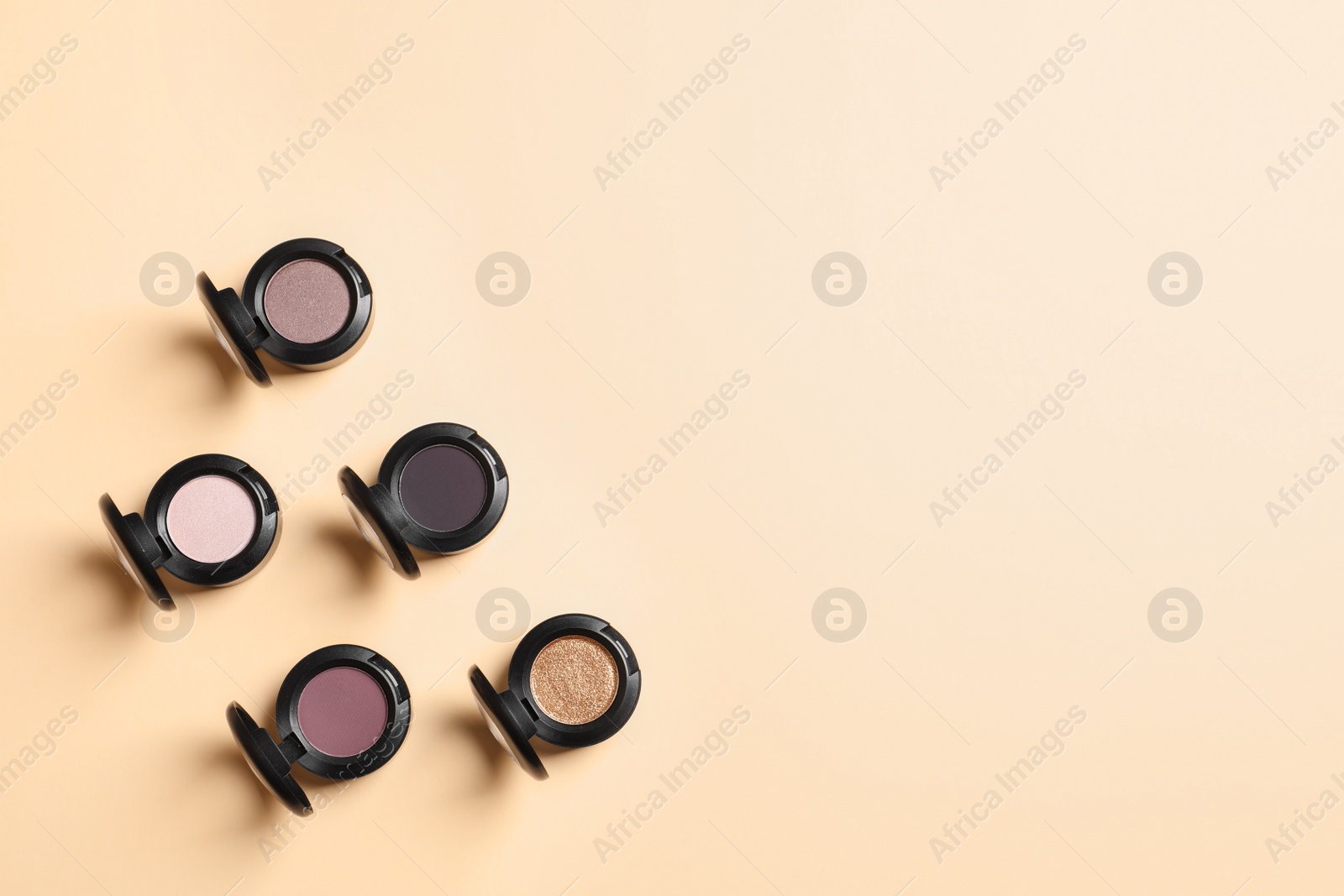 Photo of Flat lay composition with different eye shadows on color background. Space for text