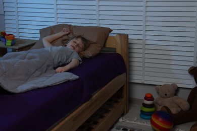 Photo of Little boy snoring while sleeping in bed at night