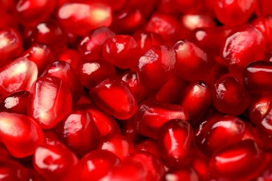 Many tasty pomegranate seeds as background, closeup
