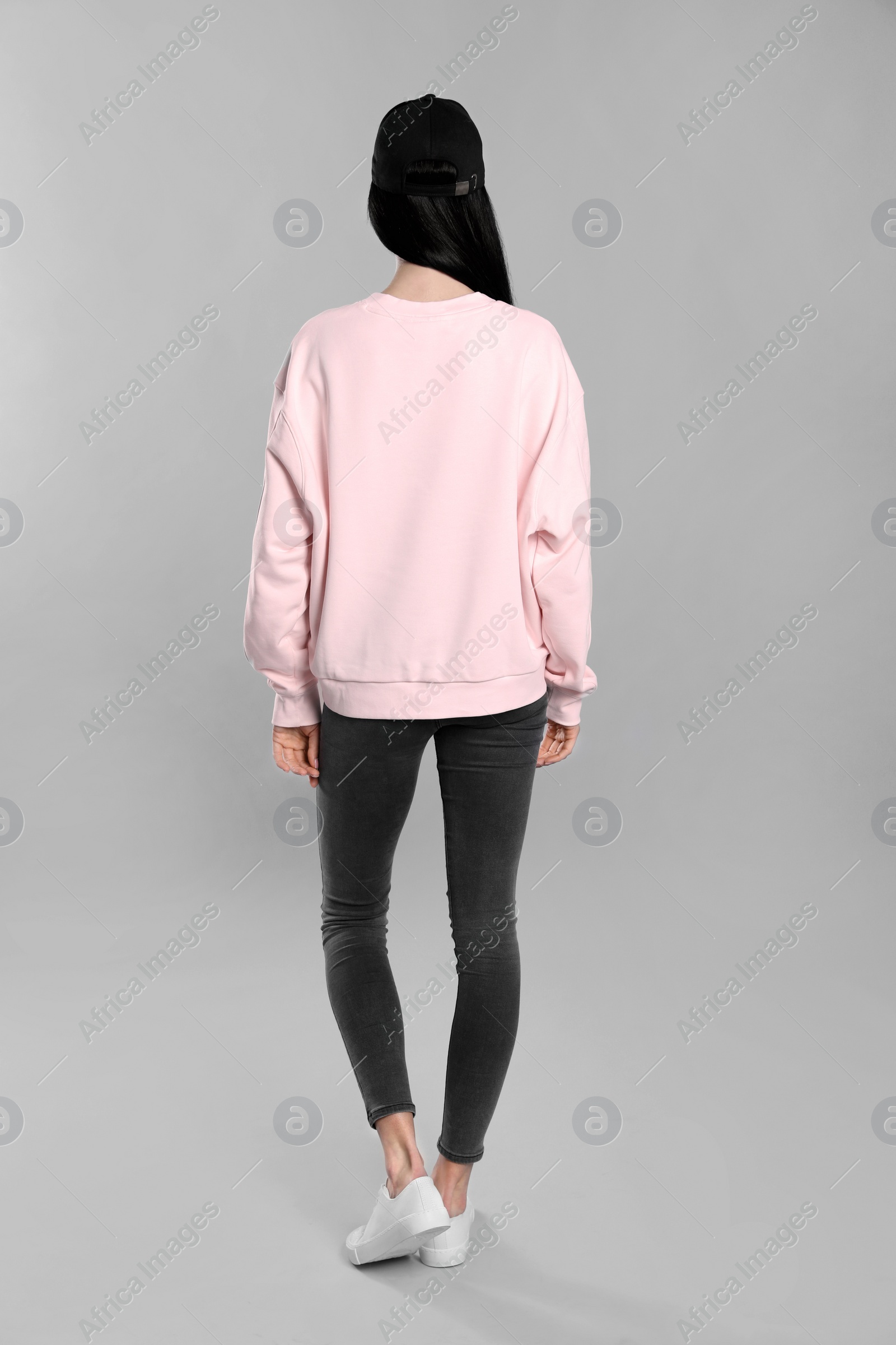 Photo of Young woman in sweater on grey background. Mock up for design