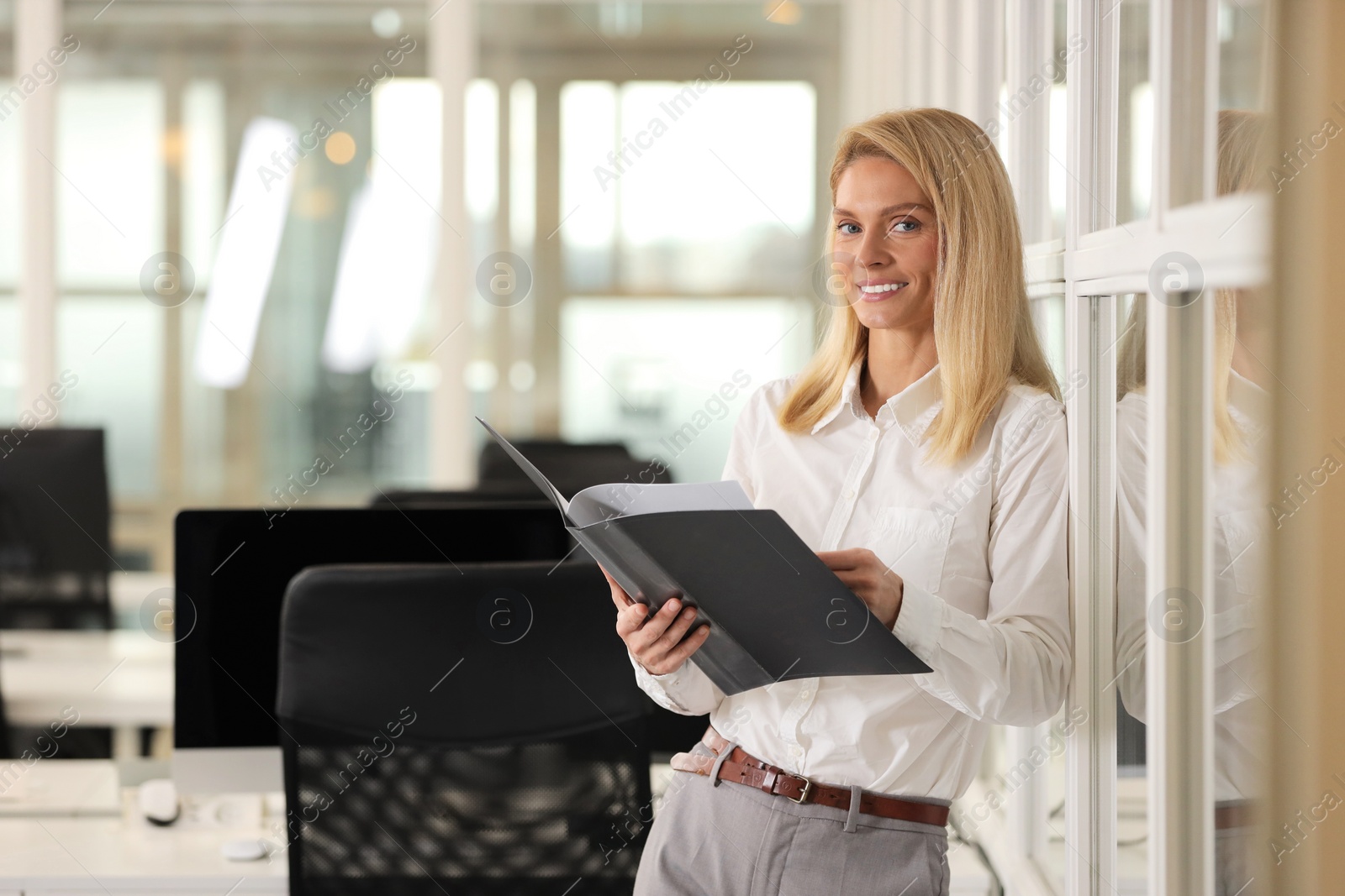 Photo of Smiling woman with folder in office, space for text. Lawyer, businesswoman, accountant or manager