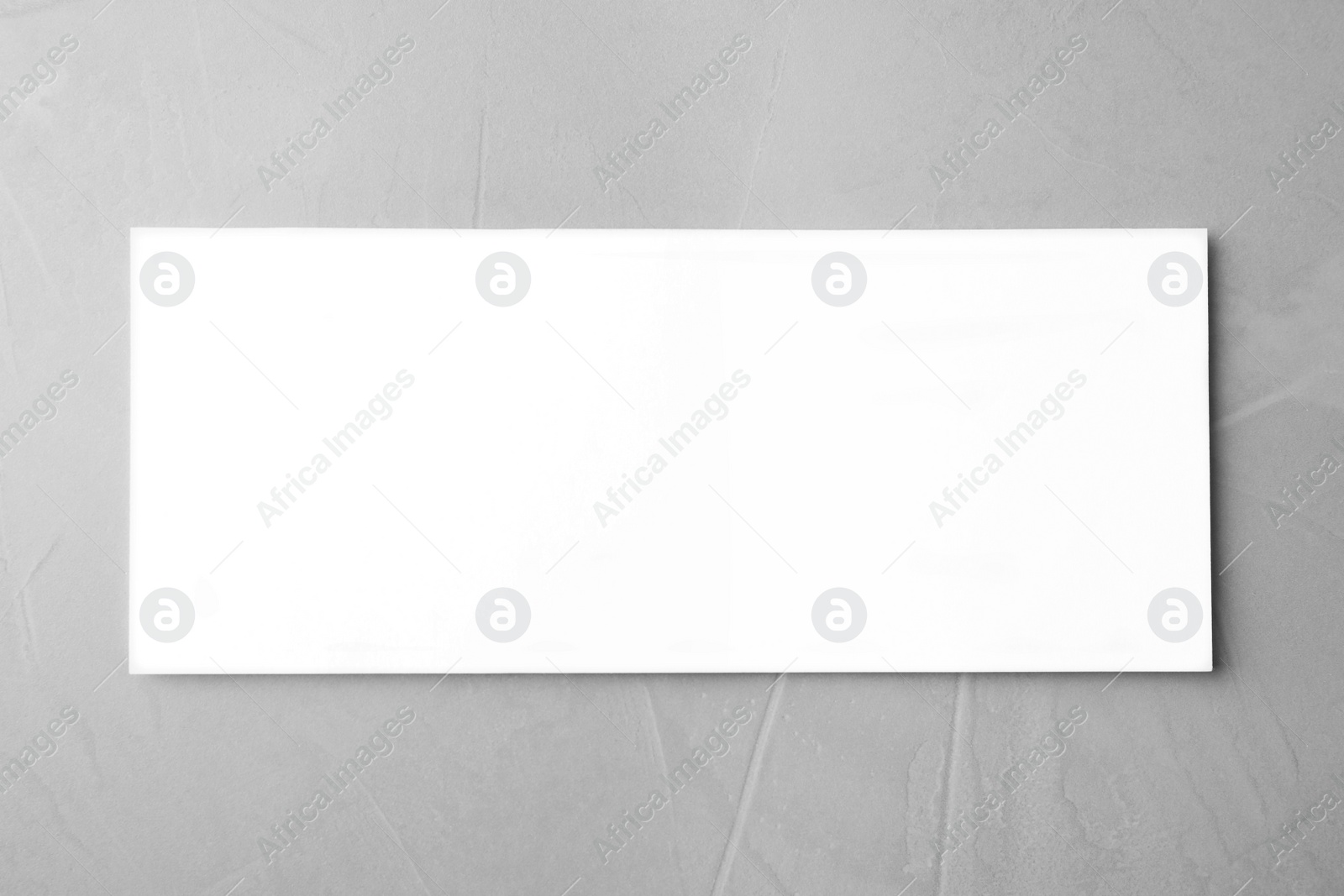 Photo of Blank palm card on light grey stone background, top view. Mock up for design