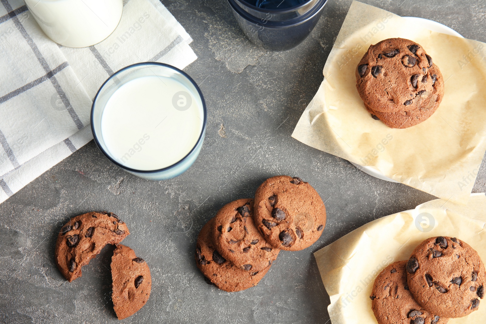 Photo of Flat lay composition with chocolate chip cookies and glass of milk on grey background