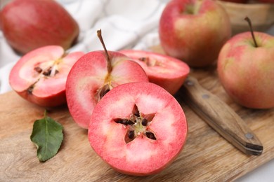 Photo of Tasty apples with red pulp and knife on table, closeup